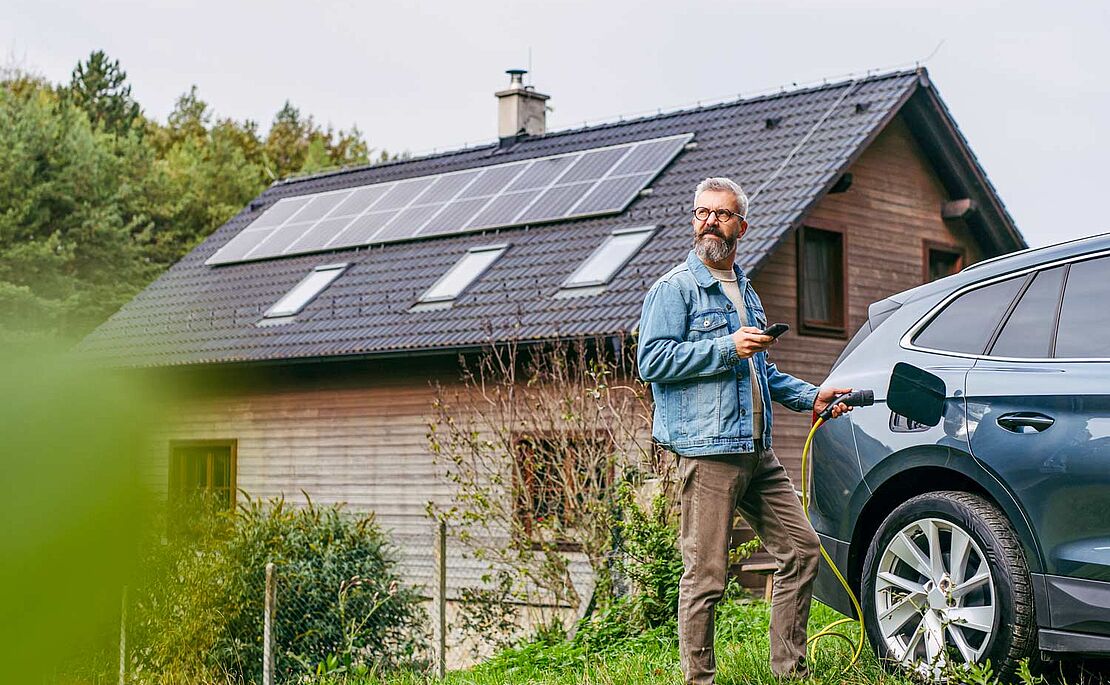 Mann beim Aufladen seines E-Autos