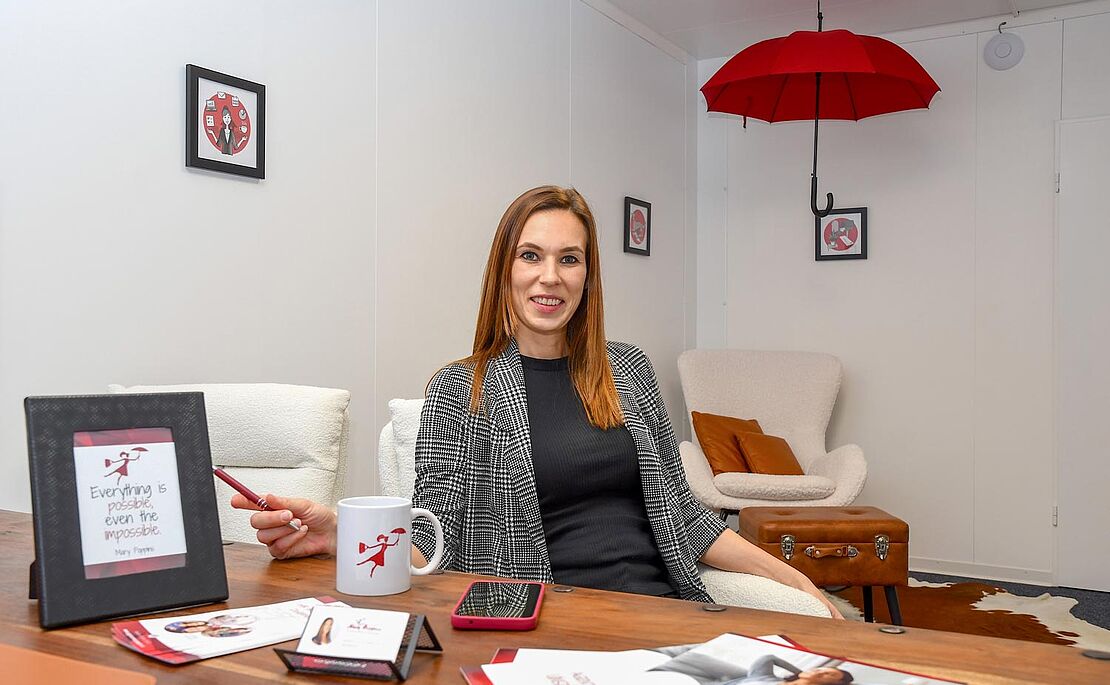 Foto von ­Sarah Lettenbichler an ihrem Schreibtisch im Standort in ­Kitzbühel